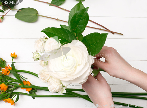 Image of Female florist making beautiful bouquet at flower shop