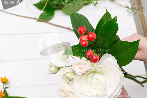 Image of Female florist making beautiful bouquet at flower shop