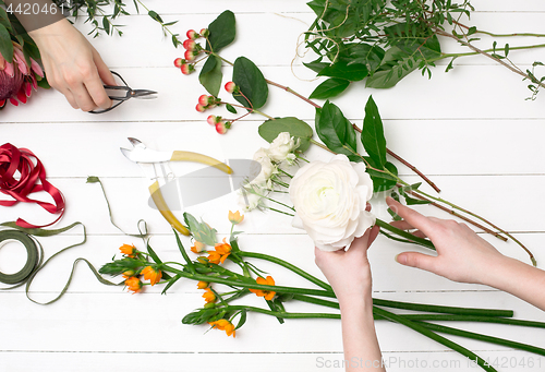 Image of Female florist making beautiful bouquet at flower shop