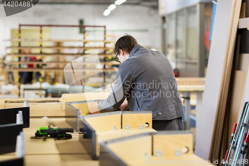 Image of assembler making furniture factory workshop