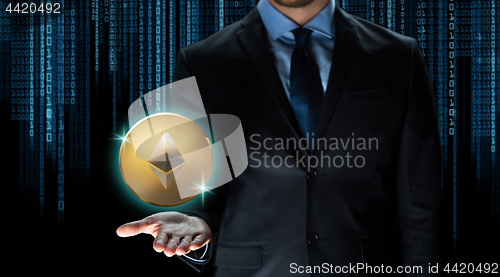 Image of businessman with ethereum coin over binary code