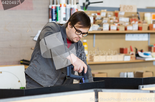 Image of assembler with screwdriver making furniture