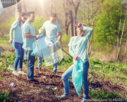 Image of volunteers with garbage bags cleaning park area