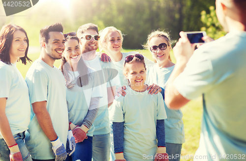Image of group of volunteers taking picture by smartphone