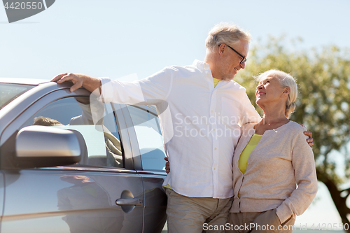 Image of happy senior couple with car in summer