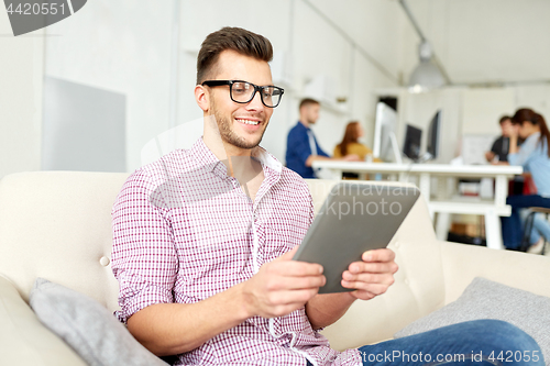 Image of man in glasses with tablet pc working at office