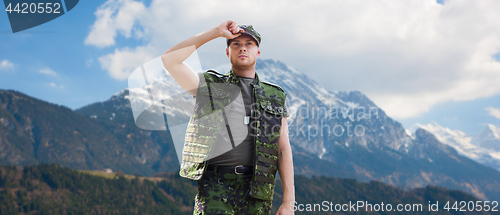 Image of soldier in military uniform over mountains