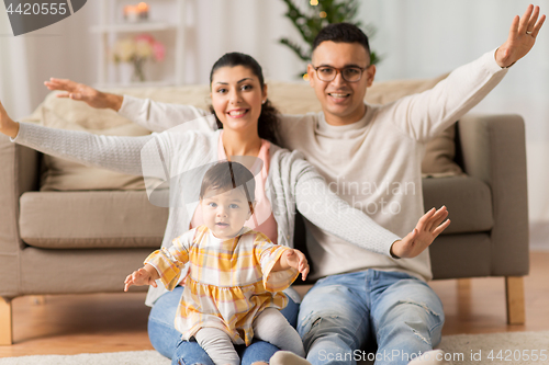 Image of happy family with baby daughter at home