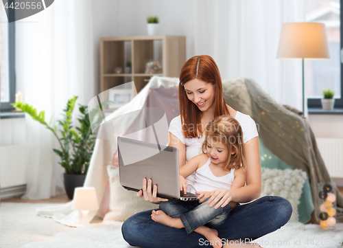 Image of happy mother with little daughter and laptop