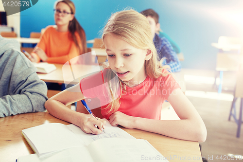 Image of student girl with book writing school test