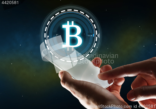 Image of businessman with tablet pc and bitcoin hologram