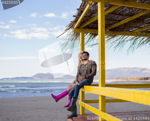 Image of young couple drinking beer together at the beach