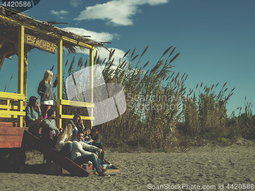 Image of Group of friends having fun on autumn day at beach