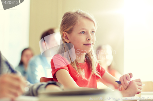 Image of group of students with notebooks at school lesson