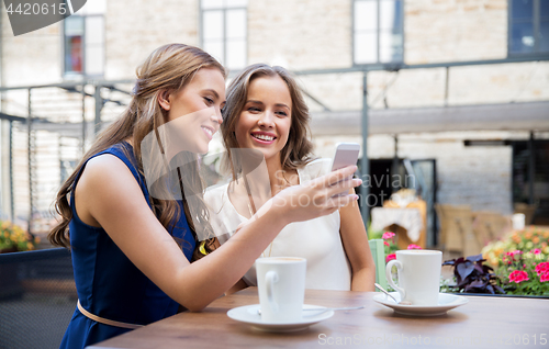 Image of young women with smartphone and coffee at cafe