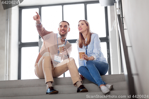 Image of man and woman with conference badges drink coffee