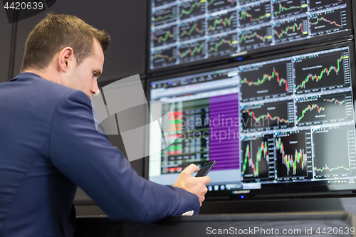 Image of Stock trader looking at market data on computer screens.