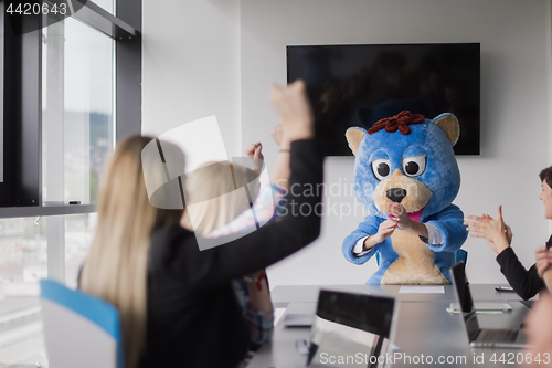 Image of boss dresed as bear having fun with business people in trendy of