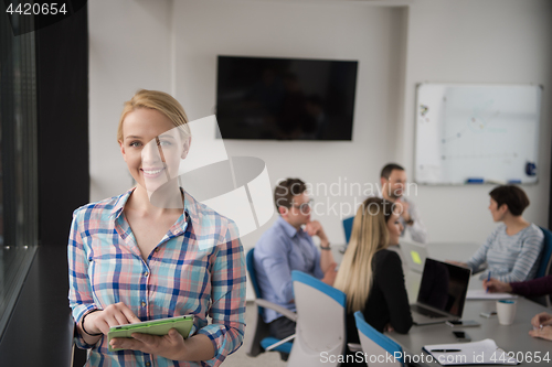 Image of Pretty Businesswoman Using Tablet In Office Building by window