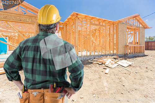 Image of Contractor Standing Outside Construction Framing of New House.