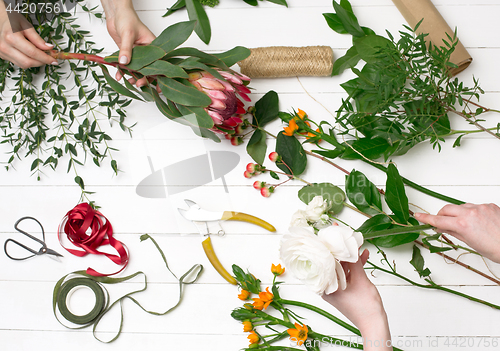 Image of Female florist making beautiful bouquet at flower shop