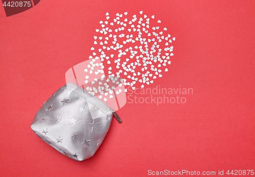 Image of Shiny silver hearts and purse on pink background