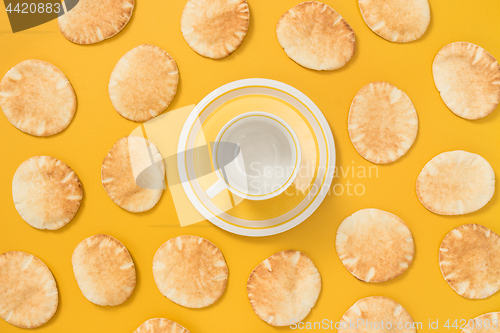 Image of Teacup and pita bread on yellow background