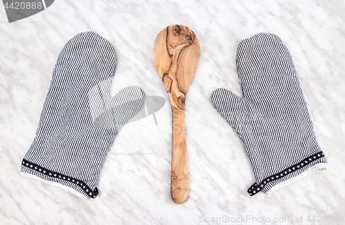 Image of Wooden spoon and striped kitchen gloves