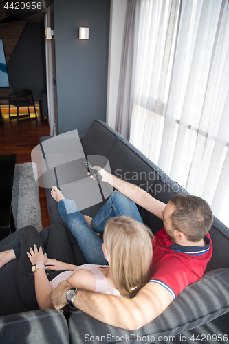 Image of Young couple on the sofa watching television