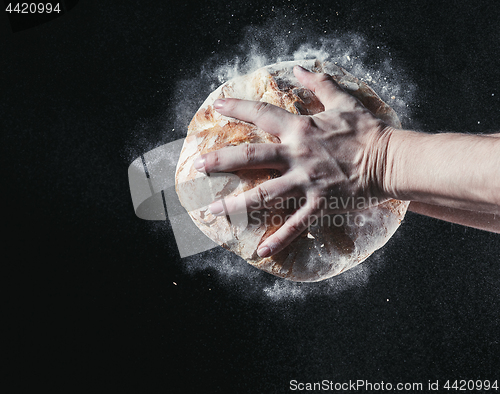 Image of Closeup of male hands put fresh bread on black background with copy space for your text