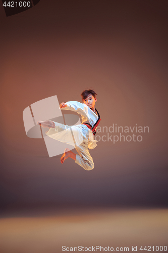 Image of Young boy training karate on blue background