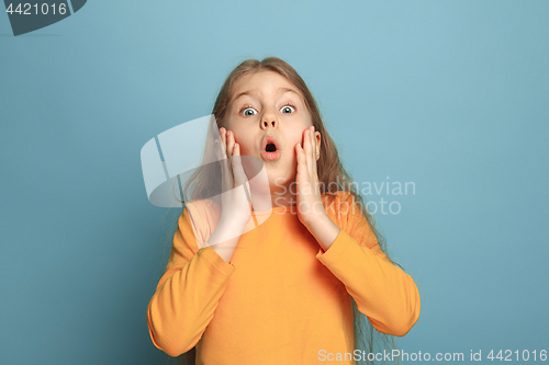 Image of The surprise, happiness, joy, victory, success and luck. Teen girl on a blue background. Facial expressions and people emotions concept