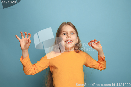 Image of The surprise, happiness, joy, victory, success and luck. Teen girl on a blue background. Facial expressions and people emotions concept