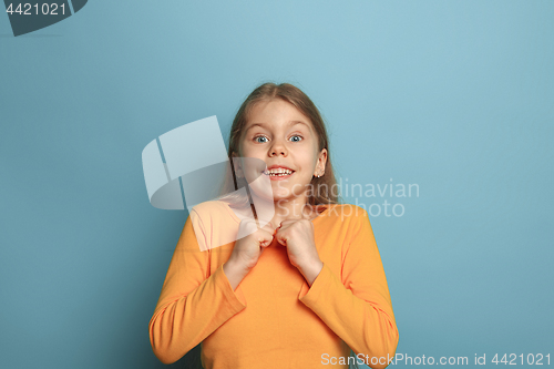 Image of The surprise, happiness, joy, victory, success and luck. Teen girl on a blue background. Facial expressions and people emotions concept