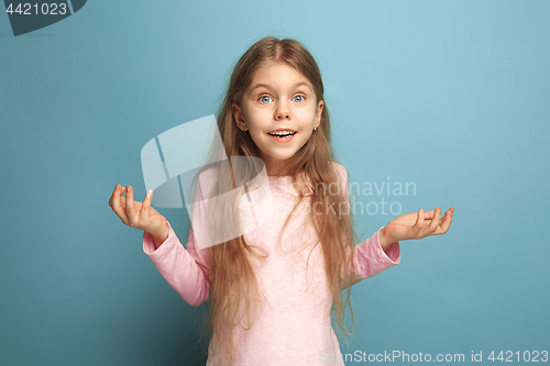 Image of The surprise, happiness, joy, victory, success and luck. Teen girl on a blue background. Facial expressions and people emotions concept