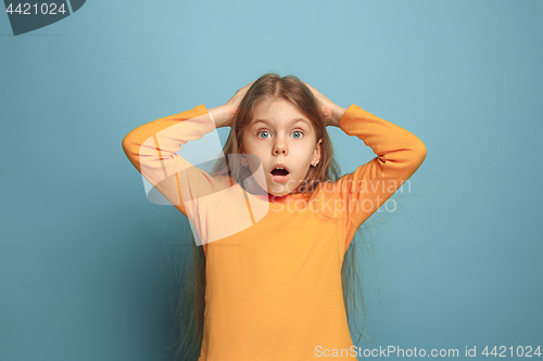 Image of The surprise, happiness, joy, victory, success and luck. Teen girl on a blue background. Facial expressions and people emotions concept