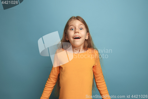 Image of The surprise, happiness, joy, victory, success and luck. Teen girl on a blue background. Facial expressions and people emotions concept