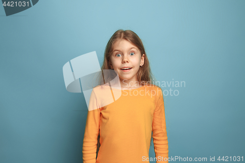 Image of The surprise, happiness, joy, victory, success and luck. Teen girl on a blue background. Facial expressions and people emotions concept