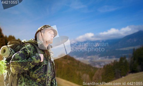 Image of soldier in military uniform with backpack hiking