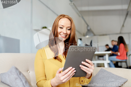 Image of redhead woman with tablet pc working at office