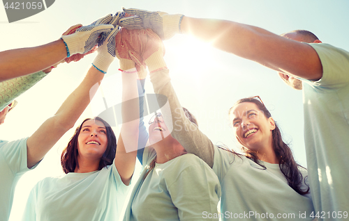 Image of group of volunteers making high five outdoors