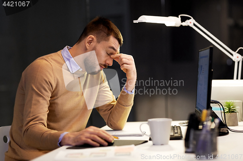 Image of tired businessman working at night office