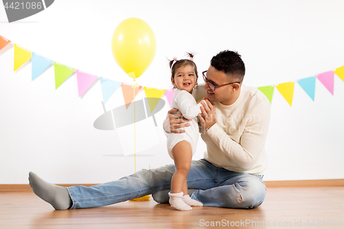 Image of happy father and little daughter at birthday party