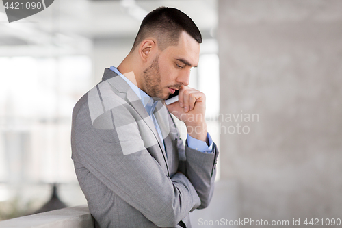 Image of businessman calling on smartphone at office