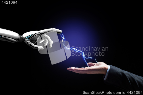 Image of robot and human hand connected by lightning