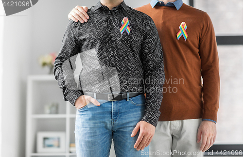 Image of close up of couple with gay pride rainbow ribbons