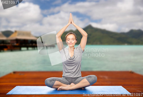 Image of woman making yoga in and meditating lotus pose