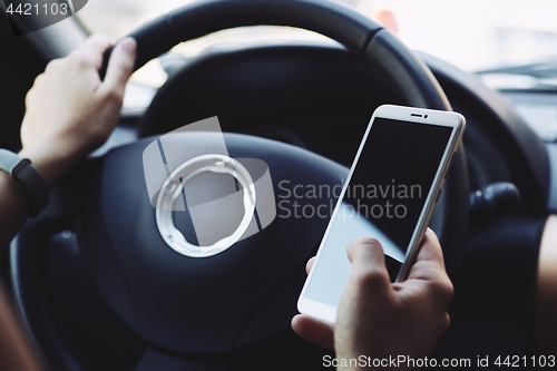 Image of Woman looking at the screen of the smartphone in the car