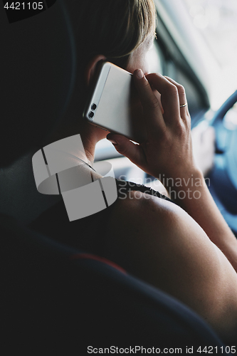 Image of Woman in the car talking on mobile phone while driving