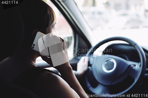 Image of Woman in the car talking on mobile phone while driving